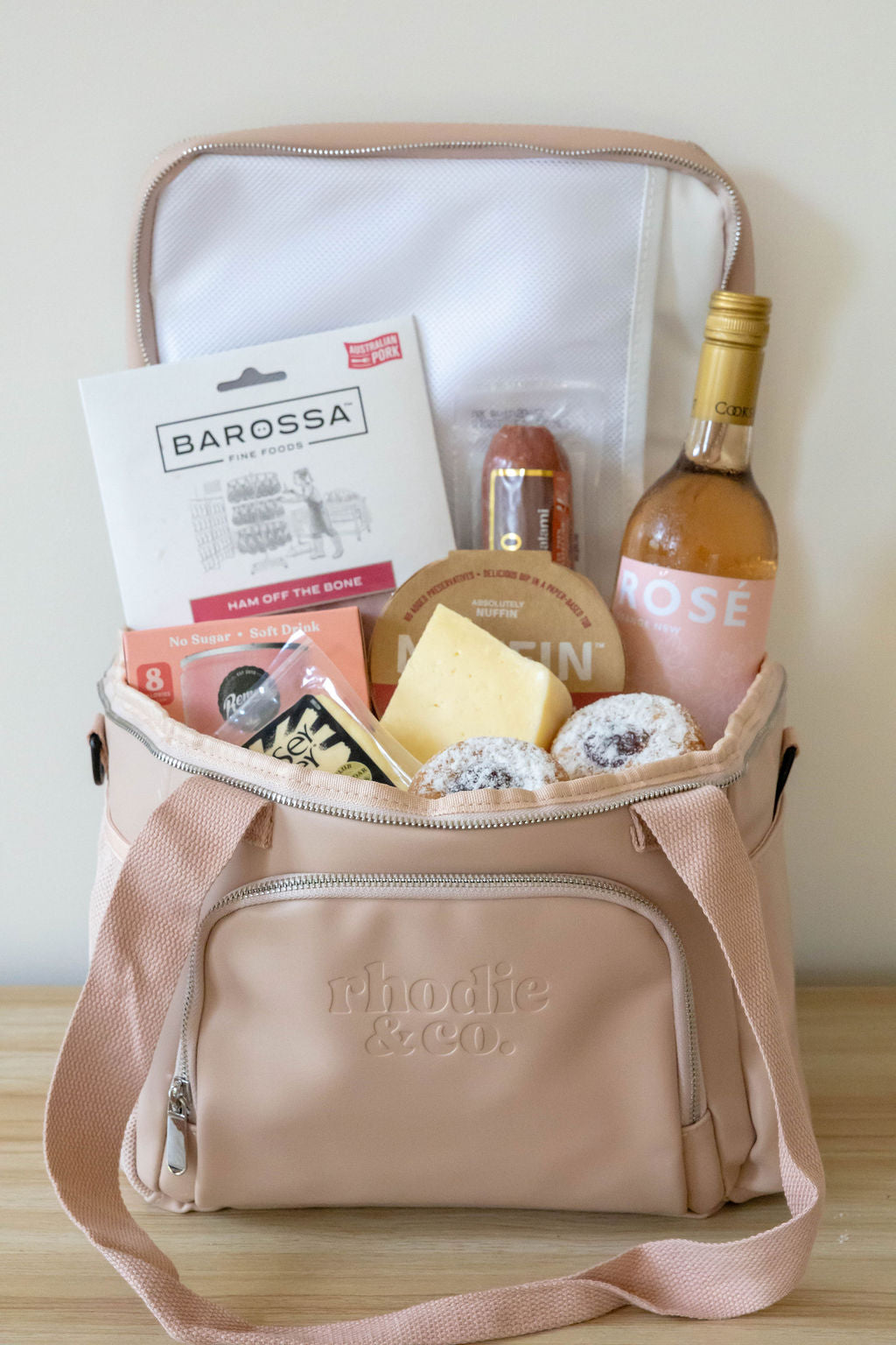 Beige thermoelectric bag with Barossa wine and snacks on a wooden surface
