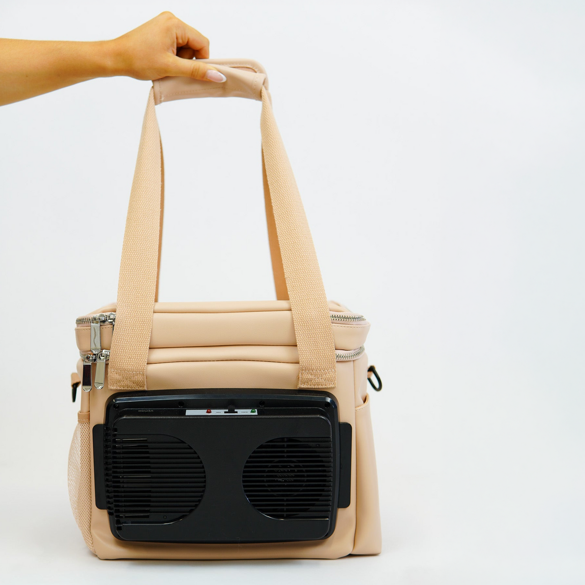 Beige cooler bag being held by the straps